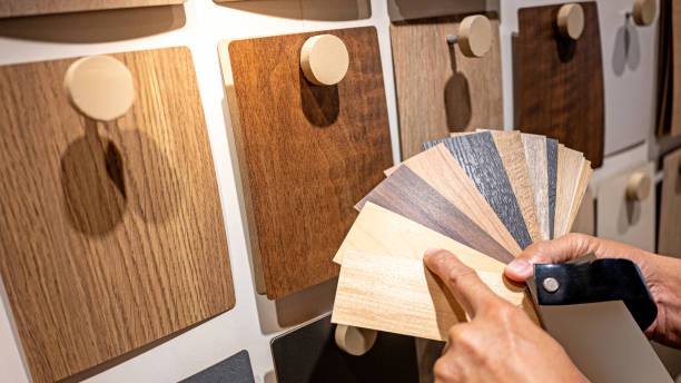 istock Designer hand pointing at sample of wood laminated from natural collection in material showroom. Choosing wooden veneer texture or MDF board swatch fan set for interior finishing or furniture design 2196284686