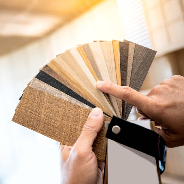 istock Designer hand pointing at sample of wood laminated material from natural collection. Customer choosing wooden veneer texture or set of MDF board swatch fan for interior finishing or furniture design 2196284705