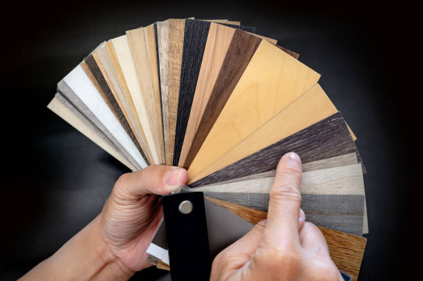 istock Designer hand pointing at sample of wood laminated material from natural collection. Customer choosing wooden veneer texture or set of MDF board swatch fan for interior finishing or furniture design 2196284779