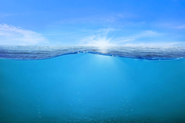 istock BLUE UNDER WATER waves and bubbles. Beautiful white clouds on blue sky over calm sea with sunlight reflection, Tranquil sea harmony of calm water surface. Sunny sky and calm blue ocean. 2196284978