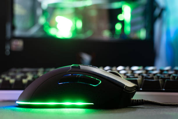 A computer mouse against the background of a keyboard and a modern computer, the organization of computer equipment