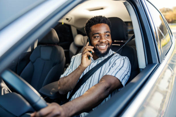 istock Happy multicultural man is driving a car and having phone pleasant phone conversation. 2196286594