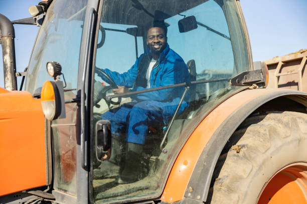 istock Young dedicated black rancher driving a tractor on farmyard. 2196286631