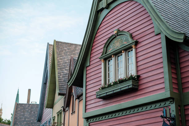 Vibrant houses with distinctive architecture line the street in this residential neighborhood. Various hues and styles create a lively atmosphere.
