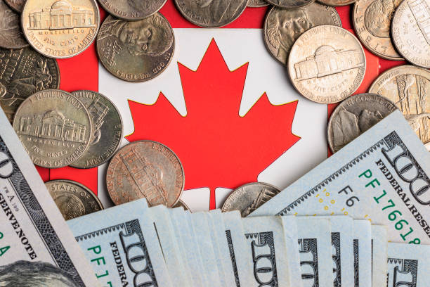 istock Canadian flag surrounded by coins and us dollars displaying economic exchange 2196302561