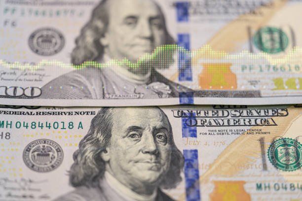istock Us dollar banknotes with financial graph overlay 2196302661
