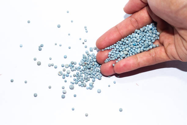 istock hand holding blue chemical fertilizer granules 2196314172