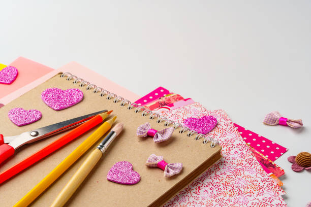 istock Crafting project with decorative supplies on a table featuring scissors, pencils, and colorful paper 2196324470