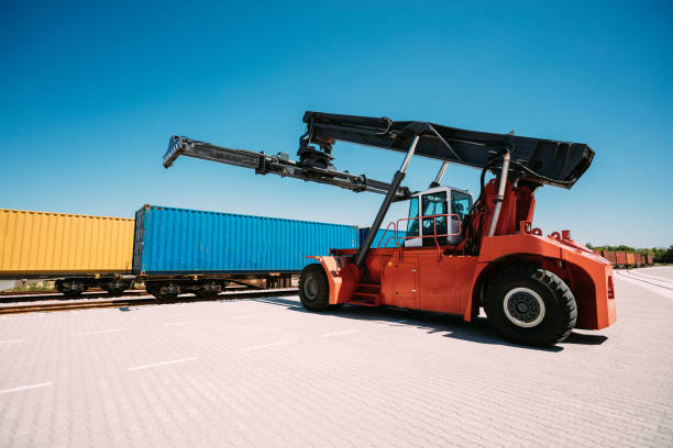 istock Industrial Reach Stacker Near Blue Shipping Container on a Sunny Day 2196324549