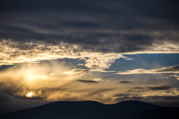 The sun sets over the mountain.