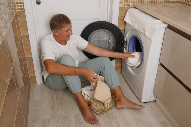 istock person loading a towel into a modern washing machine during a laundry day at home 2196325956