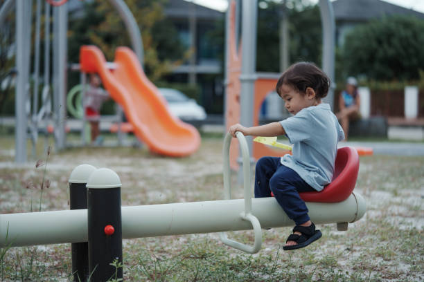 Young boy playing at yard on fitness machine.