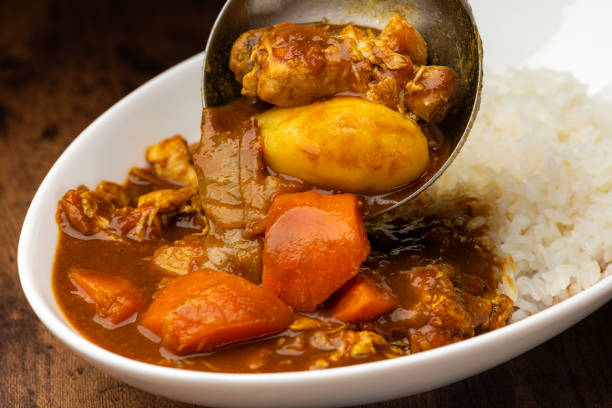 Pouring Curry Over White Rice with Ladle