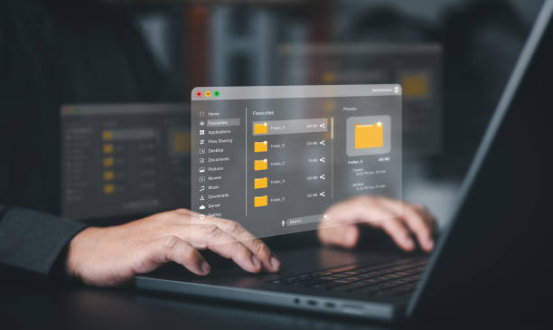 istock Businessman uses a computer laptop to manage files on document server. DMS, Cloud backup online documentation, and digital storage software. Data upload, download, share, user permission grant access. 2196331400