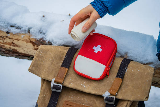 istock Hiker taking bandage from first aid kit in winter forest 2196332807