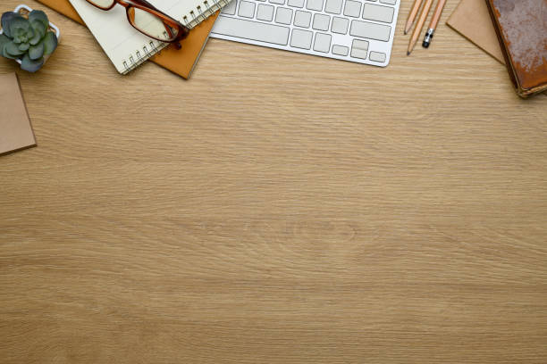 Minimalist workspace with with keyboard, notepads, glasses and a small succulent plant