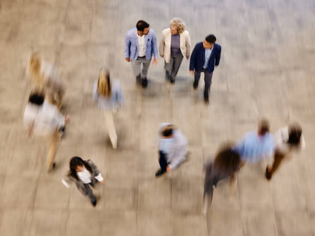 Above view of happy colleagues talking on the move in blurred motion.