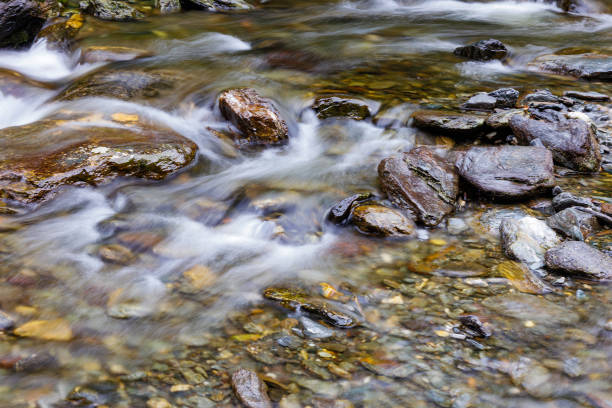 long exposure of a River stream on mountain valley. Slow motion surface boiling water in the mountain river. Fresh water bubbling from source. cropped