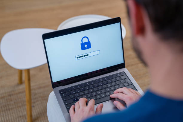 istock Man typing password on laptop with lock icon on screen 2196340491