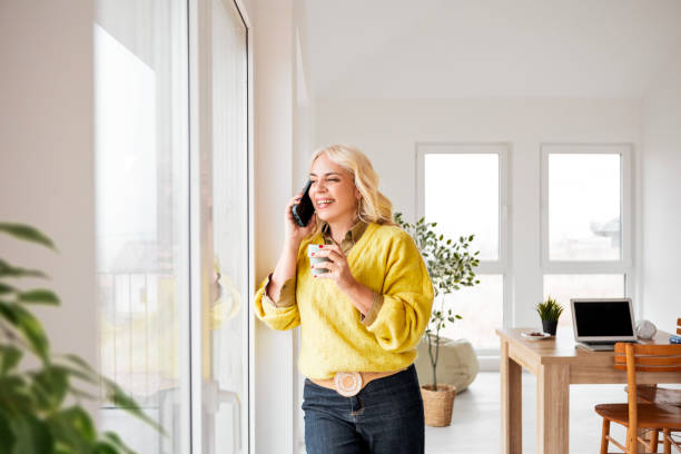 istock Woman drinking coffee and using a smart phone 2196342180