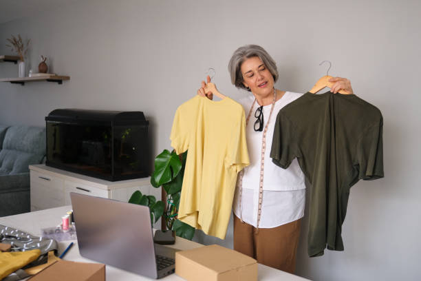 istock Senior Woman Choosing Between Two T-Shirts at Home 2196342298