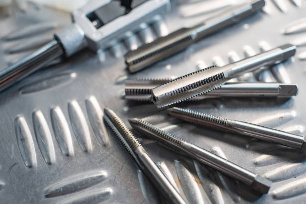 istock Tapped Hole or Threaded Hole tools on Diamond metal plate ,screw hand tap cutting tool. tap and drill bit making hole.selective focus 2196343282