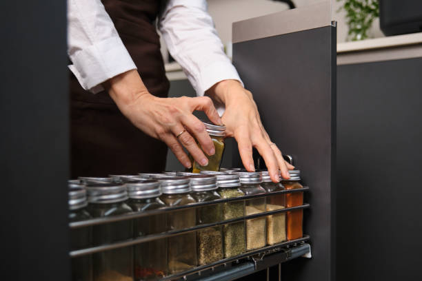 Chef is taking a jar of spices from the kitchen cabinet