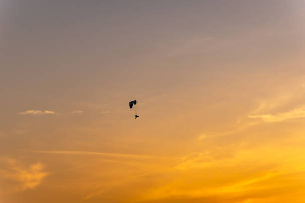 para motors flying in pristine sunset dramatic orange sky at dusk image is taken at Kutch Rann Utsav dhordo kutch white rann gujrat india.