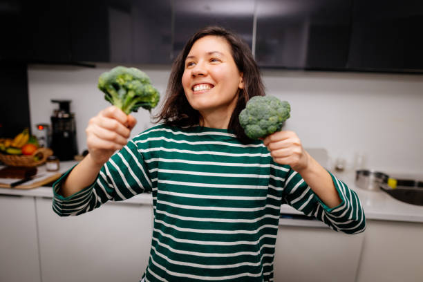 istock Woman enjoying with fresh broccoli on the kitchen 2196346993
