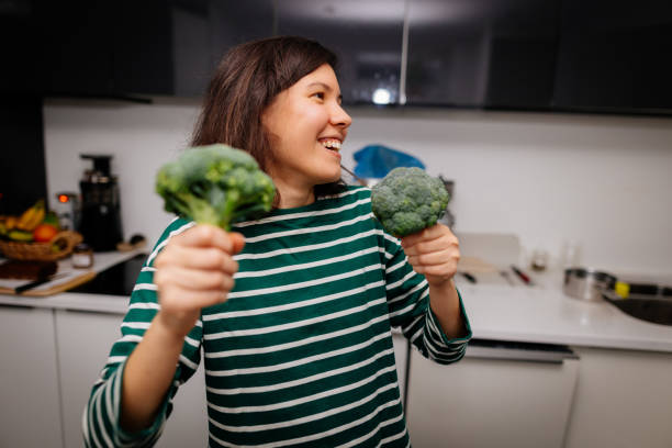 istock Woman enjoying with fresh broccoli on the kitchen 2196347028