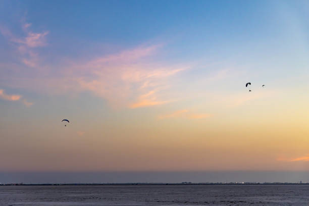 para motors flying in pristine sunset dramatic blue sky at dusk is taken at Kutch Rann Utsav dhordo kutch white rann gujrat india.