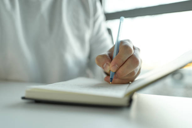 istock Businessman writing notes in notebook at office desk 2196348309