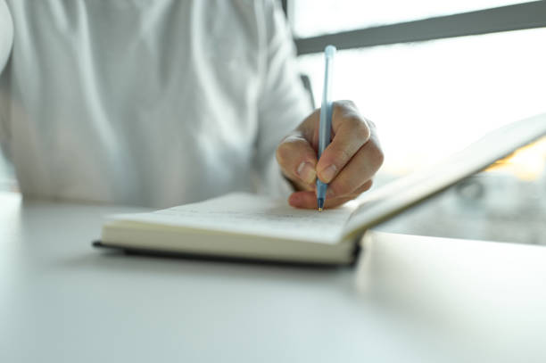 istock Businessman writing notes in notebook at office desk 2196348312