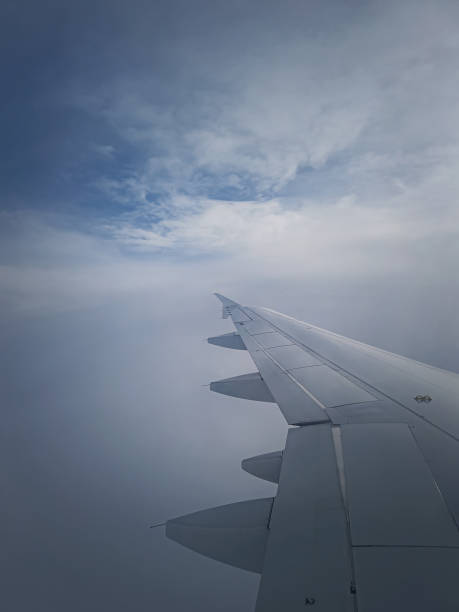istock Plane flight through the dense foggy clouds, vertical shot. Airplane wing seen through the window 2196348582