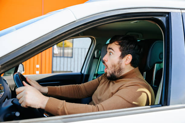 istock Side view young man guy holding a steering wheel, eyes and mouth wide open, surprised. 2196348660