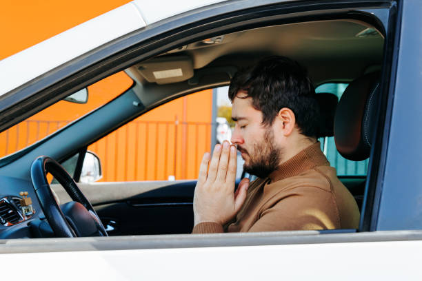 istock Calm expression on face with hands folded at face and his eyes closed, the young man sits and prays. 2196348662