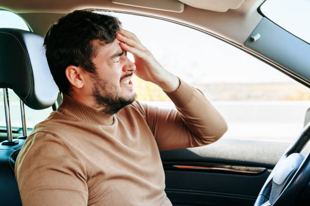 istock A sharp headache forced the male driver to stop right on the road, twisted his face. 2196348683