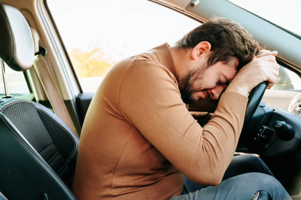 istock A sleeping tired driver stopped on the side of the road to rest. 2196348690