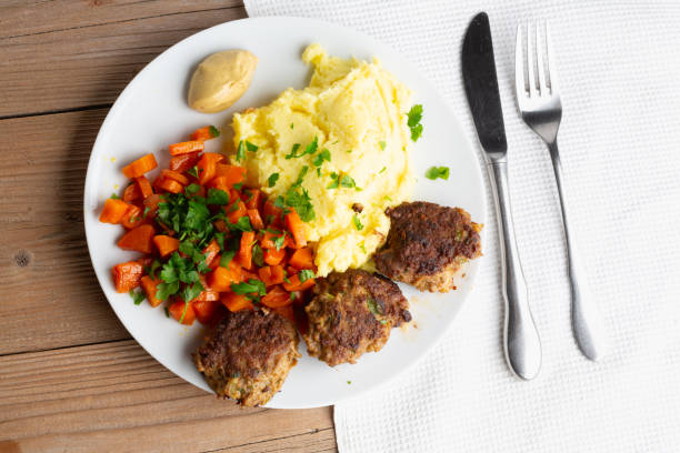 Fried liver with onion and apple, served with boiled potatoes and pickled cucumber.
