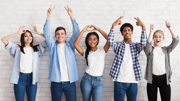 istock Teen friends gesturing with hands over white wall 2196351035