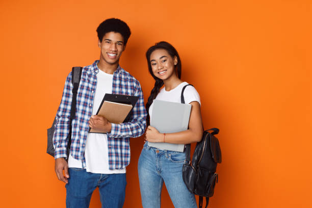 istock Happy students wearing backpacks and holding exercise books 2196351055