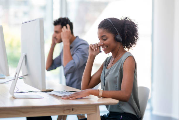istock Smiling Call Center Agent Assisting Customers on a Modern Desktop Setup 2196353227