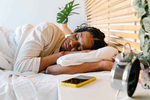 istock Woman sleeping peacefully, hugging soft pillow while lying comfortably in bed 2196358620