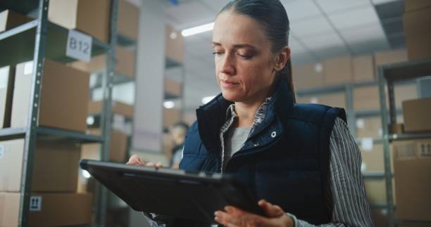 istock Female Logistics Specialist Uses Tablet Computer, Checks Inventory 2196361126