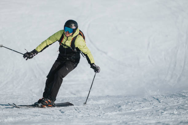 istock Male skier in motion on snowy slope under clear sky 2196361157