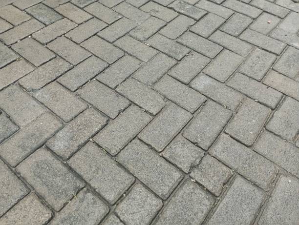 istock The surface and pattern of the sidewalk tiles. The street pathway is constructed using sections of tiles or bricks, featuring a gray tone in the outdoor setting 2196362214