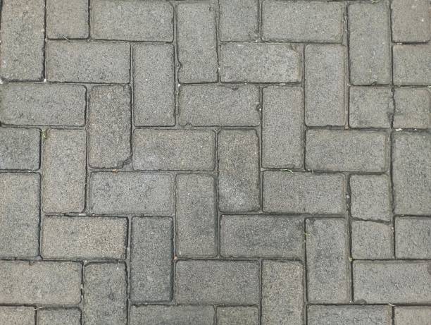 istock The surface and pattern of the sidewalk tiles. The street pathway is constructed using sections of tiles or bricks, featuring a gray tone in the outdoor setting 2196362218
