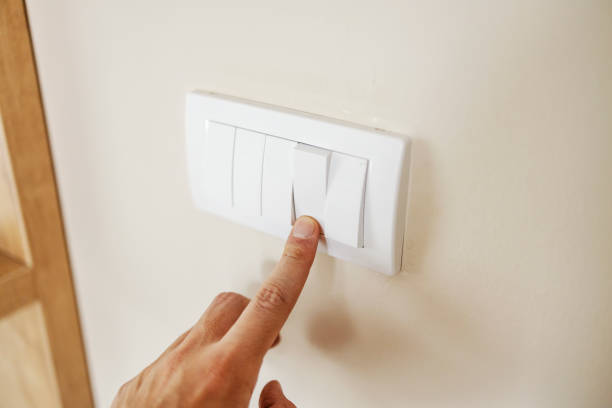 istock Close up of hand turning on lights at home. 2196362924