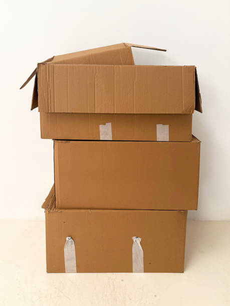 istock Brown cardboard boxes stacked on top of each other on a beige background 2196364876