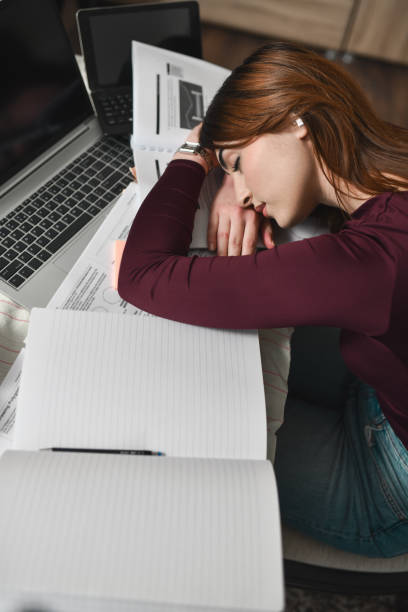 istock Tired Female Student Falling Asleep in Front of Laptop After Long Nigh Studying Session 2196365428